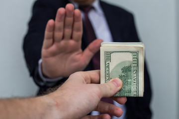 Bribe and corruption, offered cash to a businessman in a suit, does not want to take them, hold...