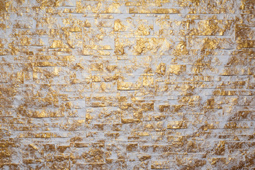 Bricks wall painted in white and gold. Background and texture. Irregular golden bricks