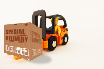 Special delivery concept with cardboard box on forklift isolated on white background
