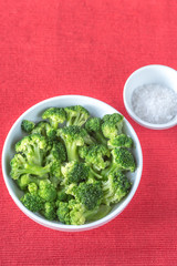 Bowl of cooked broccoli with seasonings