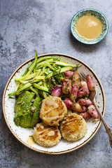 Vegetarian bowl of zucchini, roast radishes, avocado, white bean patties and white miso dressing
