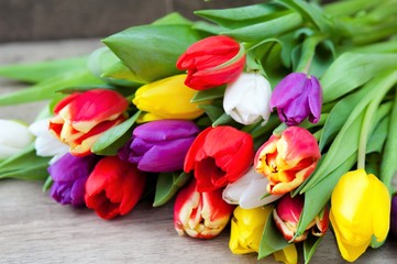 Easter eggs and fresh spring tulips on a wooden background, tulips on a wooden background