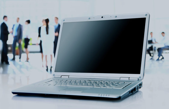 Modern laptop isolated on white with reflections on glass table.