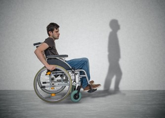 Young disabled man on wheelchair has hope for recovery. His shadow is walking near.