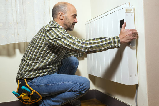 electrician installing radiator at home