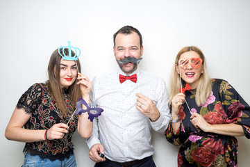 three people girls man posing party props photo booth white plain background studio hat