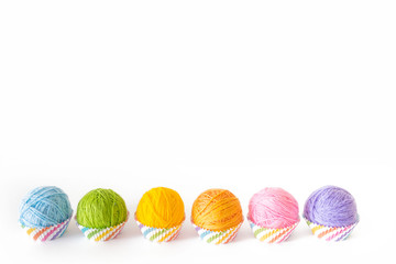 Colored yarn in the form of capkeys or mafins. Colors of rainbow. Isolate. White background.