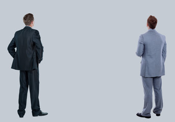 two business mans from the back - looking at something over a white background.