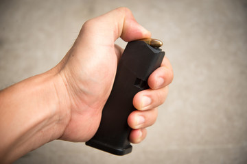 hand loading 9mm bullets into the gun magazine