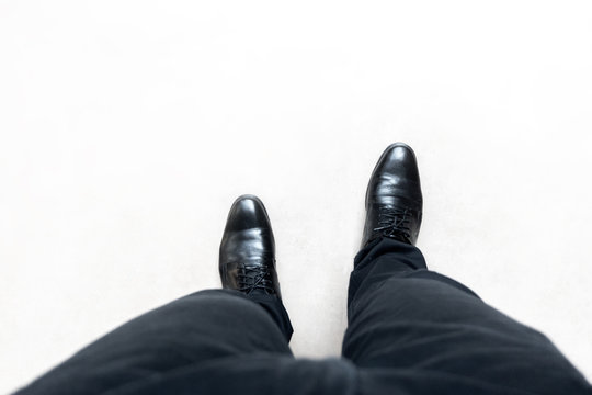 Top View Feet Of Businessman In Black Shoes Walking On Grey Road. Walking Go To Dream Concept.