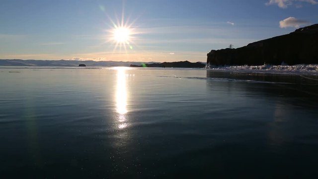 The sun reflected on the surface of clean and smooth ice in motion