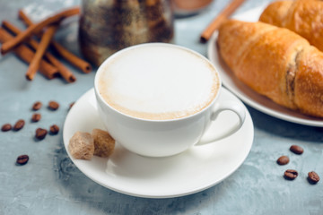 Cup of coffee with croissants on the rustic wooden background. Selective focus. Shallow depth of field.