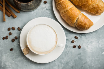 Cup of coffee with croissants on the rustic wooden background. Selective focus. Shallow depth of field.