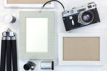 old memories concept - retro camera, empty photo frames, negative films and tripod on white wooden...