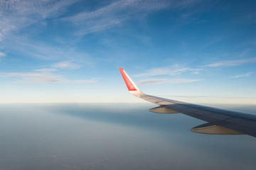 Fototapeta na wymiar Wing of an airplane in morning sunrise .