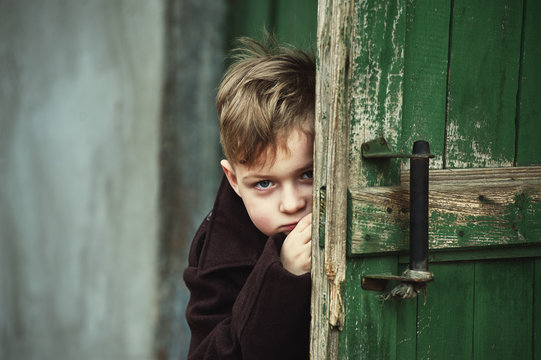 Funny Boy Peeking Out From Behind The Door