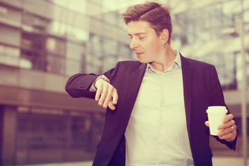Businessman hurrying to meeting and watching on wristwatch