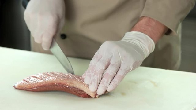 Chef scoring duck breast. Raw poultry meat.