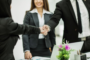 handshake successful business partners in the workplace in the o