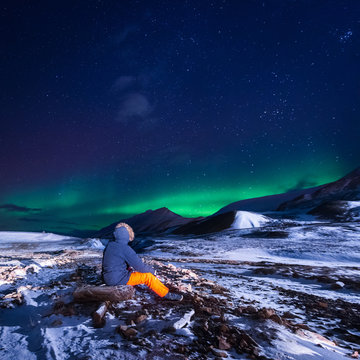 The polar arctic Northern lights aurora borealis sky star in Norway Svalbard in Longyearbyen city town mountains