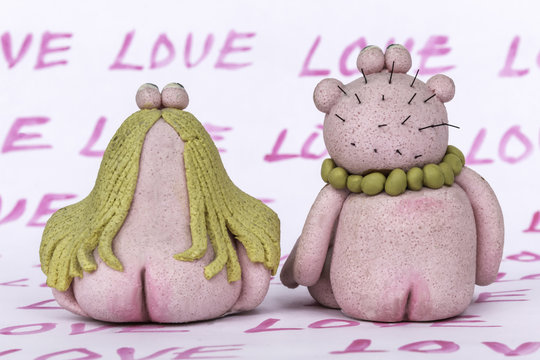 Toys "man" and "woman" from dough and salt . Valentine's day . Handmade.  The word "Love" as a horizontal background .