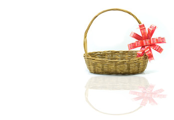 Fototapeta na wymiar Empty wicker basket with red and gold ribbon isolated on white background