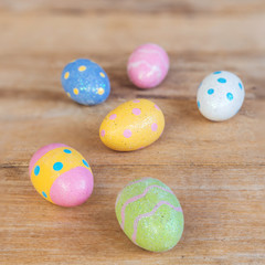 Obraz na płótnie Canvas Colorful easter eggs on plank wooden background with space.