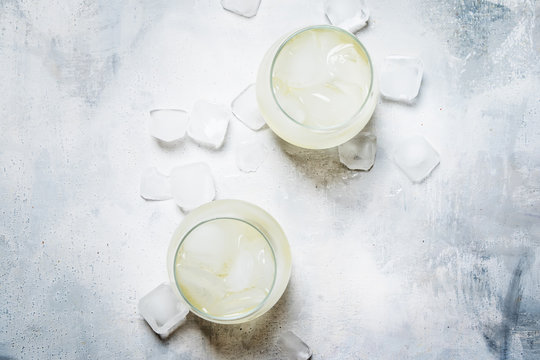 Festive Alcoholic Cocktail Prosecco On The Rocks With Dry Sparkling Wine And Ice Cubes, Gray Stone Background, Top View