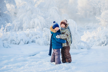 Fototapeta na wymiar two boys playing in a winter forest, the brothers
