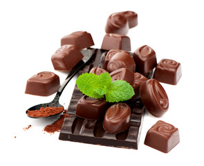 Chocolate, chocolate candy and cocoa powder on white background