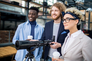 Business team with optical device for longdistant observations looking forwards