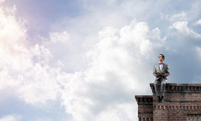 Young businessman or student studying the science on building roof