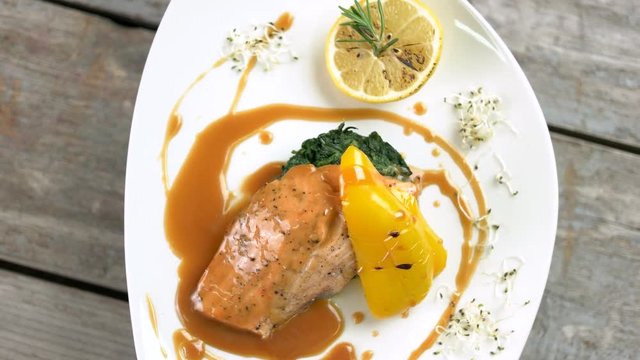 Grilled salmon, vegetables and sauce. Delicious restaurant food top view.