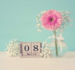 Image of International women day concept with beautiful flower in the vase on wooden table.