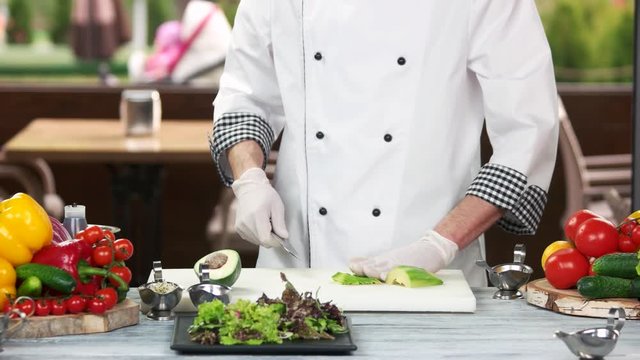 Chef cutting avocado. Food preparation, fruit and vegetables.