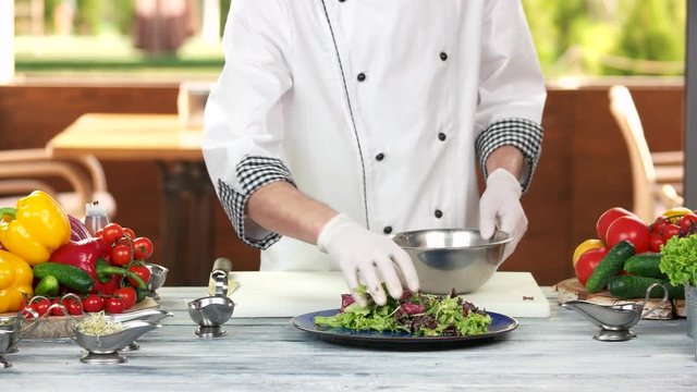 Chef making a lettuce salad. Food preparation in restaurant kitchen.