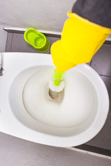 Hand in yellow gloves dirt toilet wash