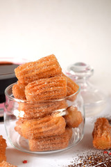Spanish cookies Churros in a glass jar and chocolate sauce in the background