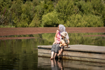 Mother and son  sitting on  wooden pier