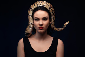 Close up portrait of woman with snake on head