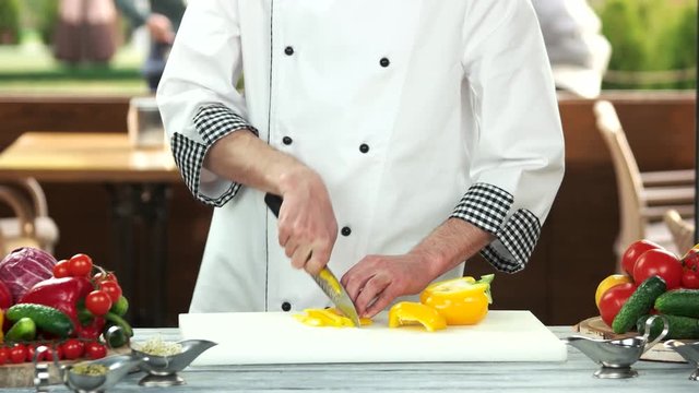 Chef cutting fresh vegetable. Food preparation, man with knife.