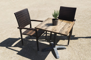 Chairs and table outdoor on terrace with rosemary flowerbed