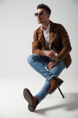 side view of a young casual man resting on  chair