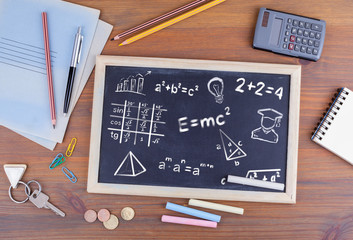 math formulas, education and knowledge concept. Chalkboard on wooden office desk.