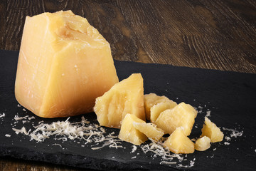 Pieces of parmesan cheese on a dark background. © vitals