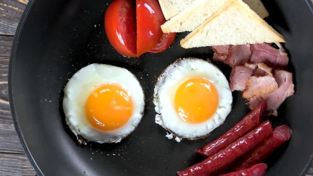 Fried eggs, sausages and tomato. Traditional English breakfast.