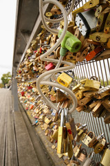 Lot hinged barn locks on the wall above the river, padlock on the bridge