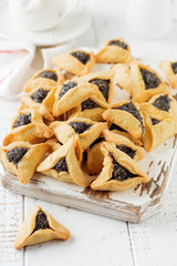 Traditional Jewish Hamantaschen cookies with berry jam. Purim celebration concept. Jewish carnival holiday background. Selective focus. Copy space.