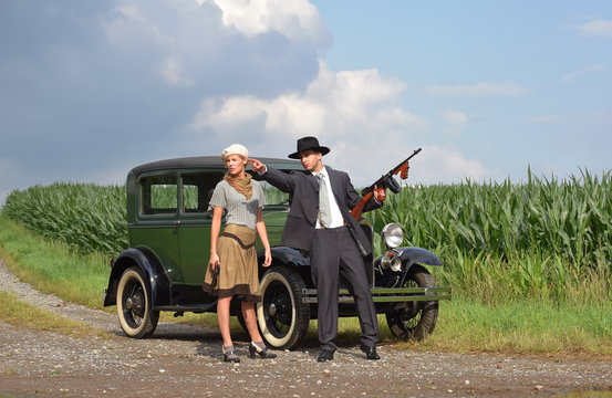 Two models get dressed up in 1930's style  vintage fashion clothes and act the role of  the gangster duo Bonnie and Clyde.