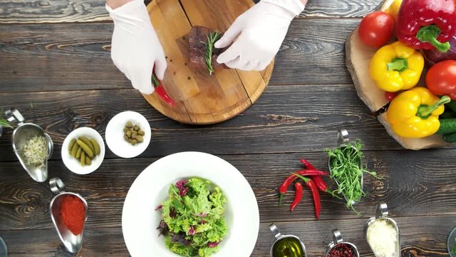 Salad preparation, wooden table. Lettuce, mustard and beef.